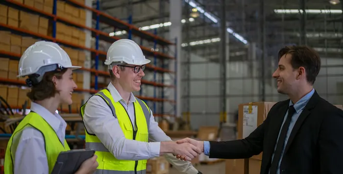 Sales leader closing a deal with an industrial client in a warehouse